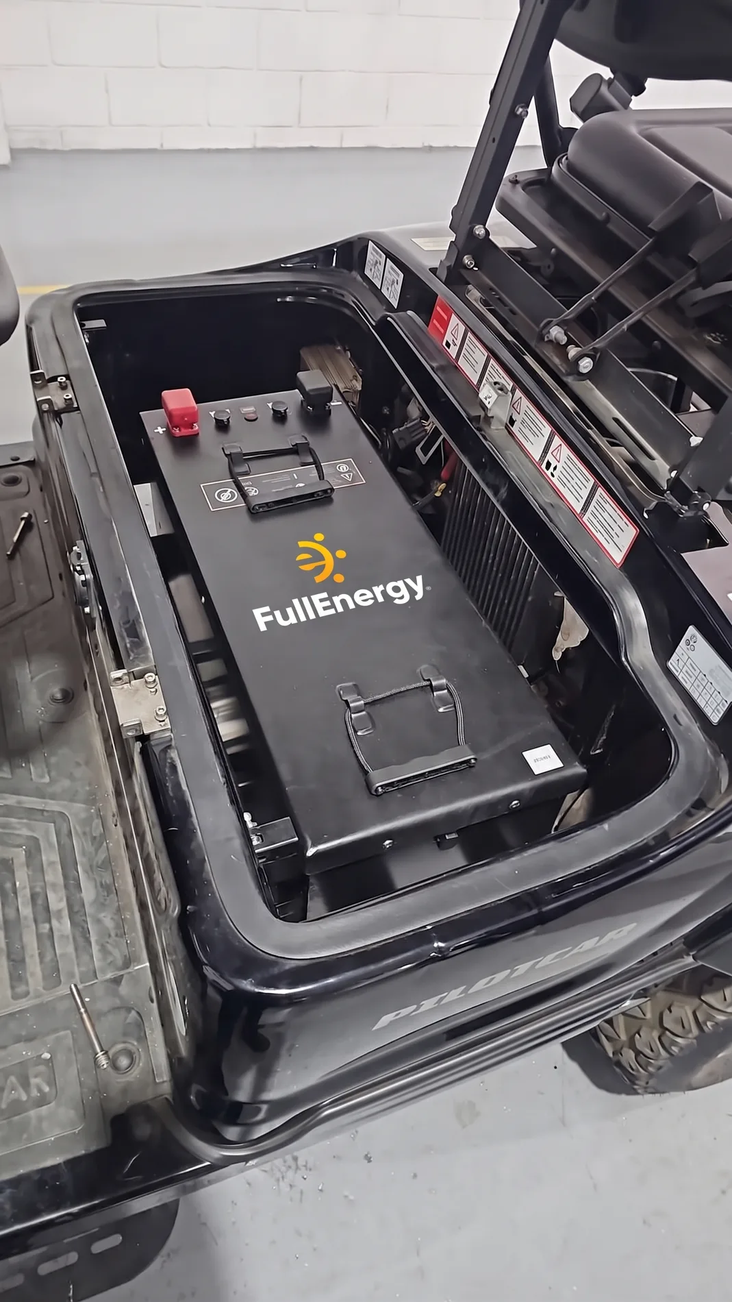 Bateria de lítio FullEnergy instalada no compartimento de um carro de golfe Pilotcar